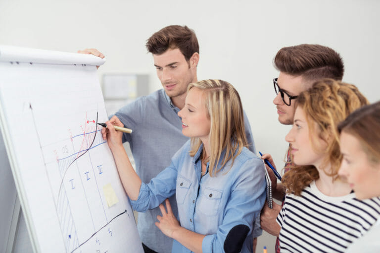 bwl studenten arbeiten zusammen am flipchart