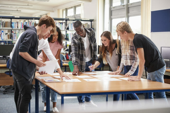 group of college students collaborating on project in library